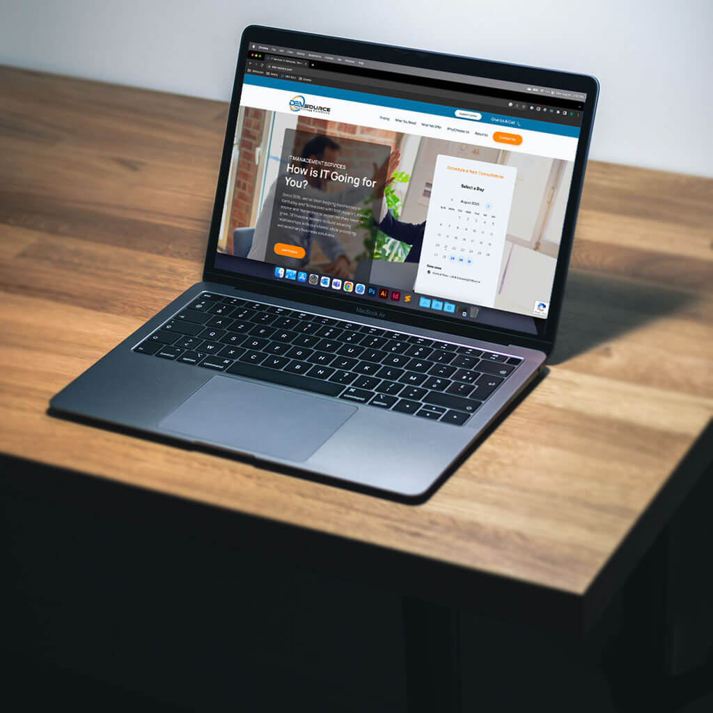 A dark-colored MacBook Air on a wooden table